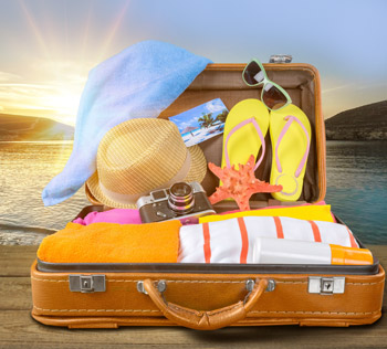 open suitcase by the water with summer travel items in it